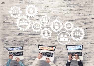 Ellerinde cihazlar bulunan üç kişilik bir grup iletişim ve ağ oluşturma sembolü olarak birlikte çalışıyor.