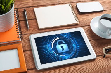 Ofis eşyalarıyla iş yeri ve ekranda asma kilit simgeleri olan tablet