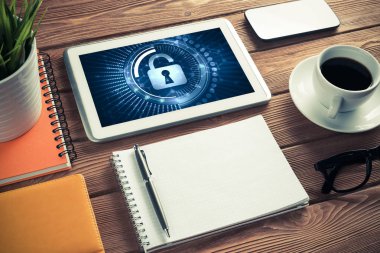 Ofis eşyalarıyla iş yeri ve ekranda asma kilit simgeleri olan tablet