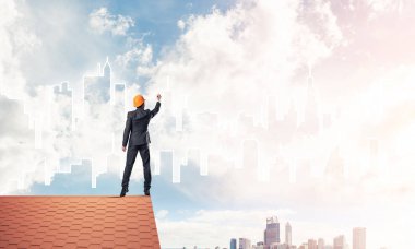 Mühendis, evinin çatısına geri döndü ve şehri çiziyor. Karışık ortam