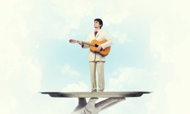 Gitar çalan garsonun eli sunar.