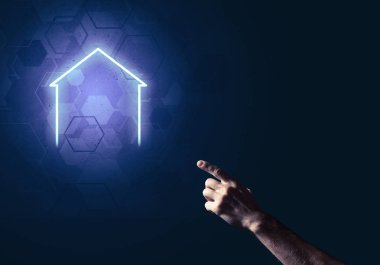 İnsanın eli parlayan ev simgesi ya da sembolüyle dokunuyor
