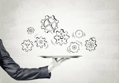 Uşak, somut arka plana karşı takım çalışması kavramına sahip metal tepsiyi tutuyor.