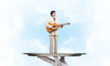 Gitar çalan garsonun eli sunar.