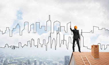 Mühendis, evinin çatısına geri döndü ve şehri çiziyor. Karışık ortam