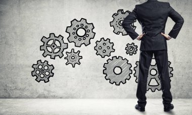 İş adamının çizilmiş dişli mekanizmasıyla duvara baktığı arka plan