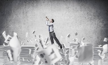 İşadamı belgeleri kağıtları gri arka plan ile uçan arasında yığını dururken fifre oynamak. Karışık teknik.