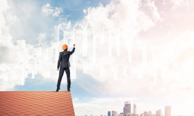 Mühendis, evinin çatısına geri döndü ve şehri çiziyor. Karışık ortam