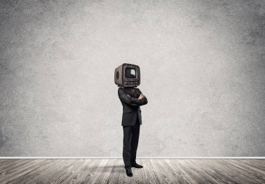 Arka plan üzerinde duran gri Duvar ile boş oda içinde iş başına silah tutmak yerine eski bir Tv ile takım elbiseli adamı geçti.