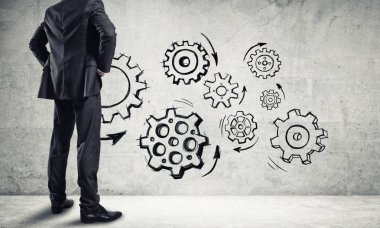 İş adamının çizilmiş dişli mekanizmasıyla duvara baktığı arka plan