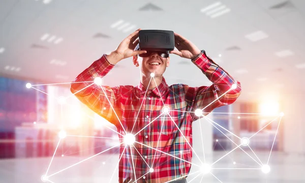 仮想現実のヘッドセットと接続の背景の上に メガネの若い男 ミクスト メディア — ストック写真