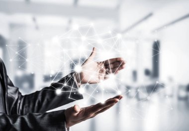 Arka plan üzerinde office manzaralı elinde beyaz sosyal medya ağ yapısını koruma kıyafetli bir iş kadını. Karışık teknik.