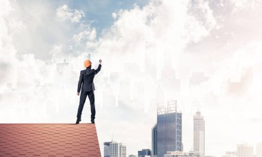 Mühendis, evinin çatısına geri döndü ve şehri çiziyor. Karışık ortam