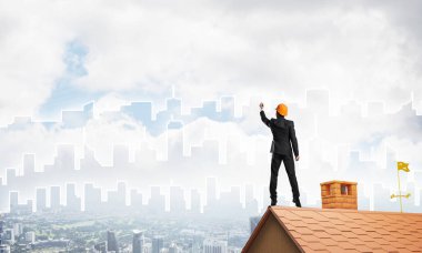 Mühendis, evinin çatısına geri döndü ve şehri çiziyor. Karışık ortam