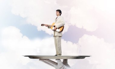 Gitar çalan garsonun eli sunar.