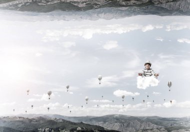 Genç küçük çocuk gözleri koruma kapalı ve seyir bulut aerostats uçan arasında ve doğa dünyalar arasında üzerinde meditasyon sırasında konsantre.