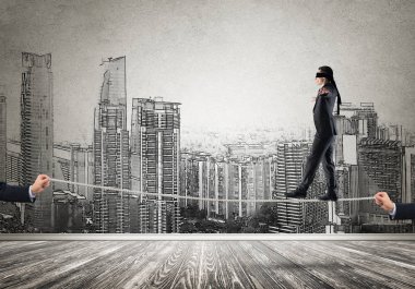 İp üzerinde yürüyen gözleri olan bir iş adamı.