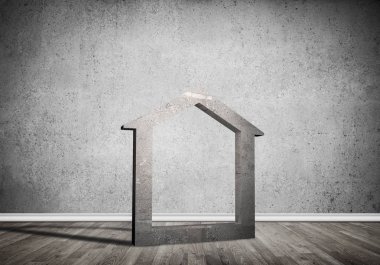 Ev taşı figürü, boş beton odadaki gayrimenkullerin sembolü.