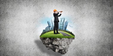 Mühendis adam beton arka planı yeşil yüzen ada üzerinde ayakta