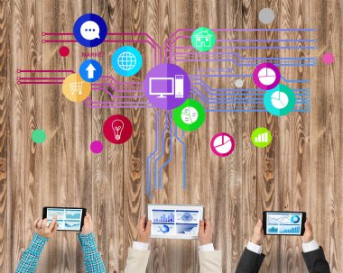 Ellerinde cihazlar bulunan üç kişilik bir grup iletişim ve ağ oluşturma sembolü olarak birlikte çalışıyor.