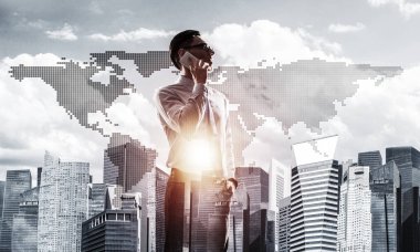 Şehre bakan ve cep telefonuyla konuşan zarif iş adamının iki kez görüntüsü.