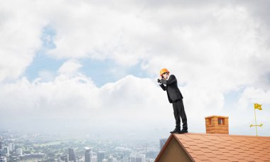 Takım elbiseli ve miğferli genç işadamı yeni bir şey arıyor. Karışık ortam