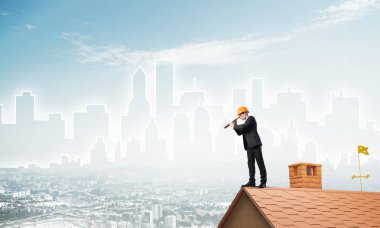 Takım elbiseli genç işadamı ve çatıda kask var. Karışık ortam