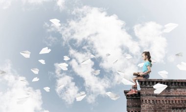 Çatı ve kitap okumak binasında oturan sevimli kız