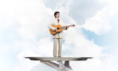 Gitar çalan garsonun eli sunar.