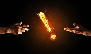 Ellerini birbirine ve yangın parlayan ünlem işareti