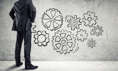 İş adamının çizilmiş dişli mekanizmasıyla duvara baktığı arka plan