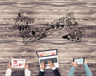 Ellerinde cihazlar bulunan bir grup insan, iletişim ve ağın sembolü olarak birlikte çalışıyor.