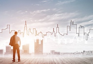 İşadamı arkasını dönüp modern iş merkezinin siluetine bakıyor.