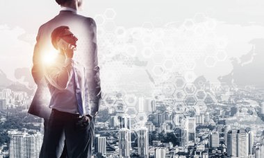 Zarif iş adamının arkası dönük ve cep telefonuyla konuşurken iki kez görüntülenmesi.