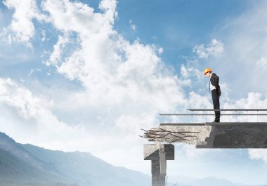 Genç takım elbiseli mühendis ve arka plan üzerinde hava ve Doğa Manzaralı Tamirhane üzerinde dururken bakıyordu kask. 3D render.