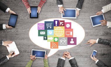 Ellerinde cihazlar bulunan bir grup insan, iletişim ve ağın sembolü olarak birlikte çalışıyor.