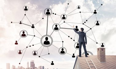 Delikanlı çatıda dikiliyor ve bağlantı hatları çiziyor. Karışık ortam