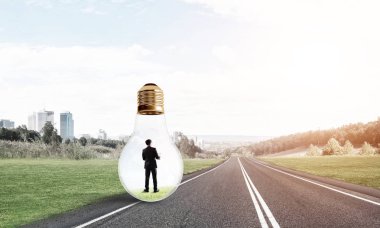 Genç işadamı asfalt yolda ampulün içinde mahsur kaldı.