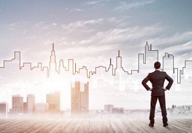 İşadamı arkasını dönüp modern iş merkezinin siluetine bakıyor.