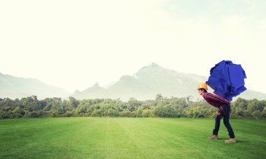 Sırtında kağıt top taşıyan inşaatçı.