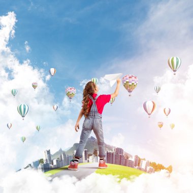 Yüzen adada kağıt uçak atan tatlı bir kız.