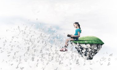 Gökyüzü adasında yüzen tatlı gülümseyen genç kız kitap okuyor.