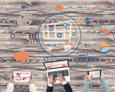 Ellerinde cihazlar bulunan üç kişilik bir grup iletişim ve ağ oluşturma sembolü olarak birlikte çalışıyor.