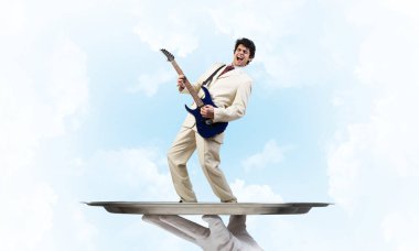 Gitar çalan garsonun eli sunar.