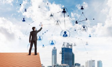 Delikanlı çatıda dikiliyor ve bağlantı hatları çiziyor. Karışık ortam