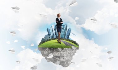 Mavi gök yeşil yüzen ada üzerinde duran zarif emin iş kadını