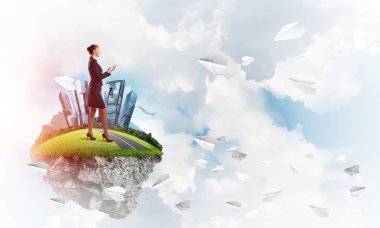 Mavi gök yeşil yüzen ada üzerinde duran zarif emin iş kadını