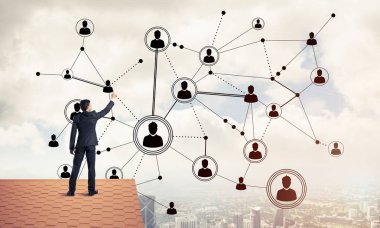 Delikanlı çatıda dikiliyor ve bağlantı hatları çiziyor. Karışık ortam