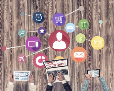 Ellerinde cihazlar bulunan üç kişilik bir grup iletişim ve ağ oluşturma sembolü olarak birlikte çalışıyor.