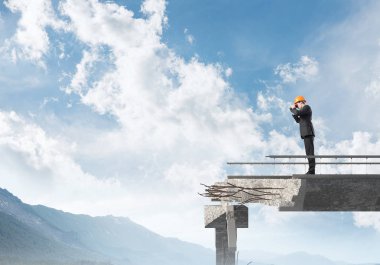 Genç takım elbiseli mühendis ve dürbün ile gökyüzü arka plan üzerinde kırık köprü üzerinde dururken seyir kask. 3D render.